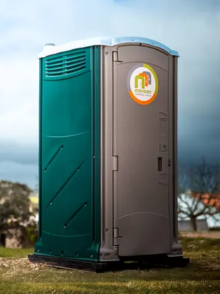 Cabine sanitária TOP, verde-petróleo e cinzenta, num relvado
